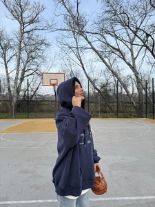 Λήψη από χαμηλή γωνία σκούρου μπλε oversized hoodie με φθινοπωρινά γραφικά σχέδια