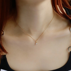 Primo piano di una collana in argento S925 placcato oro 14K con ciondolo in zircone