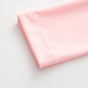 Vue détaillée d'une combinaison moulante rose avec des coutures à double aiguille