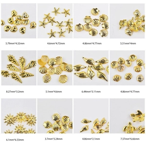 Goldene Nagelkunst-Anhänger mit Meeresmotiven wie Seesternen und Muscheln auf Gitteranzeige