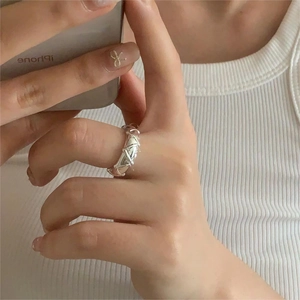 Macro detail of a geometric woven S925 sterling silver ring showing hollow 3D structure