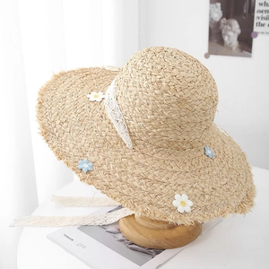 Handwoven straw sun hat with blue knit flowers and lace ribbon for summer beach vacation
