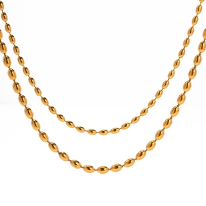 Double-layered gold stainless steel bead necklace with oval links on a white background