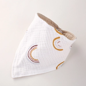 Détail du bavoir bébé en gaze de coton avec motif arc-en-ciel et texture douce