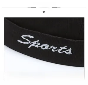 Detail of white Sports embroidery on a black docker hat with clear fabric texture