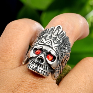 Détail d'une bague tête de mort vintage avec coiffe indienne et yeux en pierres rouges
