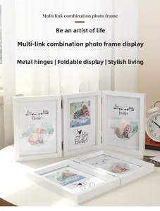 Detail of white multi-panel folding photo frame with metal hinges in a minimalist style