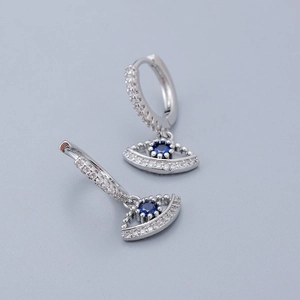 Macro shot of silver evil eye earrings with blue crystals and sparkling zircons