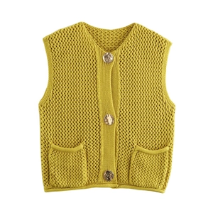Dettaglio del gilet giallo in maglia grossa con bottoni in metallo e tasche frontali