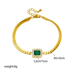 Elegant gold bracelet with emerald green zircon pendant and white crystals on white backdrop