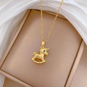 Macro shot of a luxury gold-toned unicorn necklace with rhinestones in a gift box