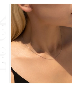 Detail of minimalist S925 sterling silver snake chain necklace on woman neck