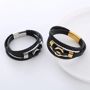 Dettaglio di bracciali in pelle nera multistrato con accenti metallici a esagono