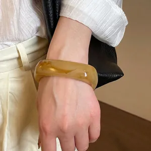 Irregular geometric resin bangle with vintage amber marble texture worn by a model