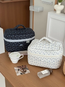 Elegant floral quilted cosmetic bags in navy and cream with top handles and bows