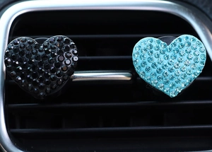 Close-up of black and blue heart-shaped rhinestone car vent clips decoration