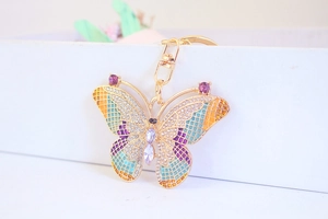 Detail view of gold butterfly keychain with colorful enamel wings and sparkling rhinestones