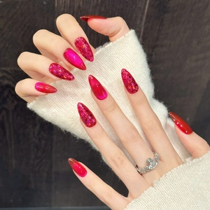 Short almond press-on nails with magenta cat-eye finish and red glitter accents
