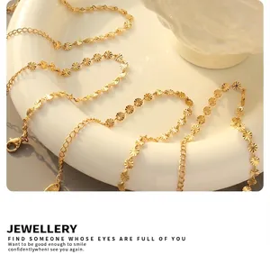 Macro shot of gold sunflower link chain on white ceramic, elegant jewelry detail