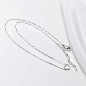 Detail of silver heart pendant with letter Q on delicate chain with lobster clasp