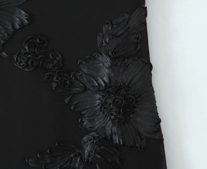Detail of 3D satin ribbon flower embroidery on a black corset dress fabric