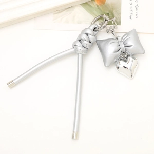 Detail view of silver PU leather bow keychain with heart and star metal charms