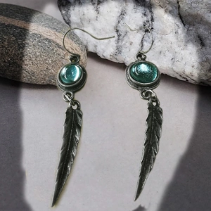 Vintage bohemian feather drop earrings with turquoise stones and aged metal texture