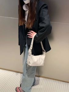 Chic white PU leather underarm bag with zipper detail styled on a model in a blazer