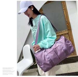 Fashionable purple large capacity travel bag worn over the shoulder by a model outdoors