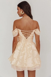 Detail view of apricot mini dress with ruffled hem and criss-cross back tie closure