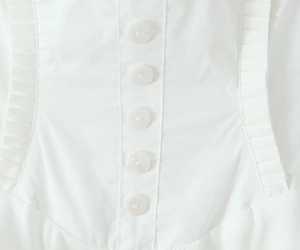 Detail of white cotton halter dress featuring five button placket and pleated stitching