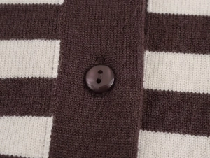 Close-up of brown and beige striped knit fabric with a detailed resin button