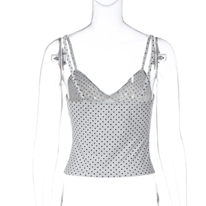 Macro detail of the slim shoulder strap and black polka dot pattern on grey camisole top