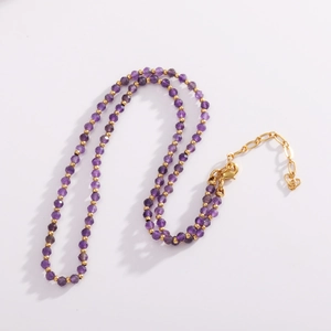 Detail of faceted purple beads and golden spacers with adjustable lobster clasp chain