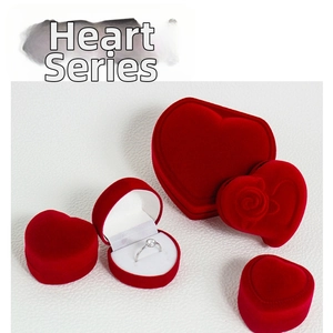 Macro shot of a red heart-shaped velvet jewelry box set with a diamond ring inside