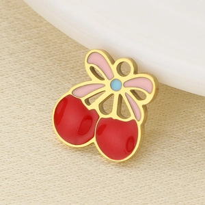 Macro shot of gold cherry pendant with red, pink and blue enamel for DIY jewelry