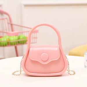 Pink mini jelly bag with glossy finish and gold chain strap on white surface