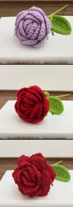 Detail of handcrafted crochet roses in purple and red yarn with green leaves decoration