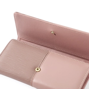 Detail view of pink patchwork wallet with wave pattern texture and snap button closure