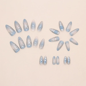 Macro detail of long stiletto press on nails with blue gradient and silver metal texture