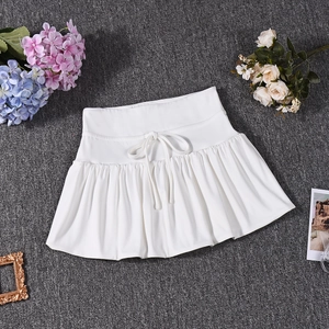 Detail of white pleated mini skirt with drawstring waist on decorative dark gray carpet