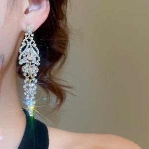 Detailed view of silver zircon tassel earrings with long drop design on a model