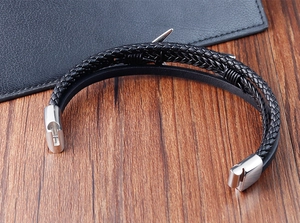 Gros plan d'un bracelet pour homme en cuir noir tressé double couche avec fermoir ancre