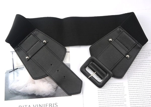 Detail of a black elastic waist belt with a faux leather buckle placed on a magazine