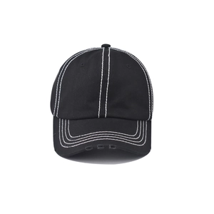 Detailed view of white double stitching and distressed holes on black cotton baseball cap