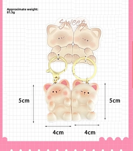 Detail view of cat couple keychains with gold snap hooks and Sweety card packaging