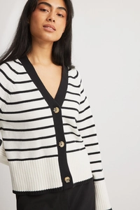 Detail eines gestreiften Strick-Cardigans mit V-Ausschnitt und klassischen Schildpattknöpfen