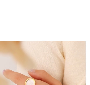 Detail of a minimalist 18K gold plated ring featuring a white mother of pearl inlay on finger