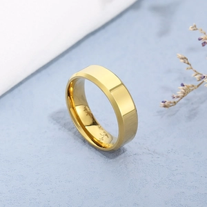 Detail showing gold beveled edge ring on light blue textured background with dried flowers