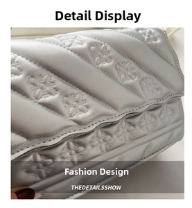 Close-up detail of silver quilted faux leather with embossed floral patterns on the bag